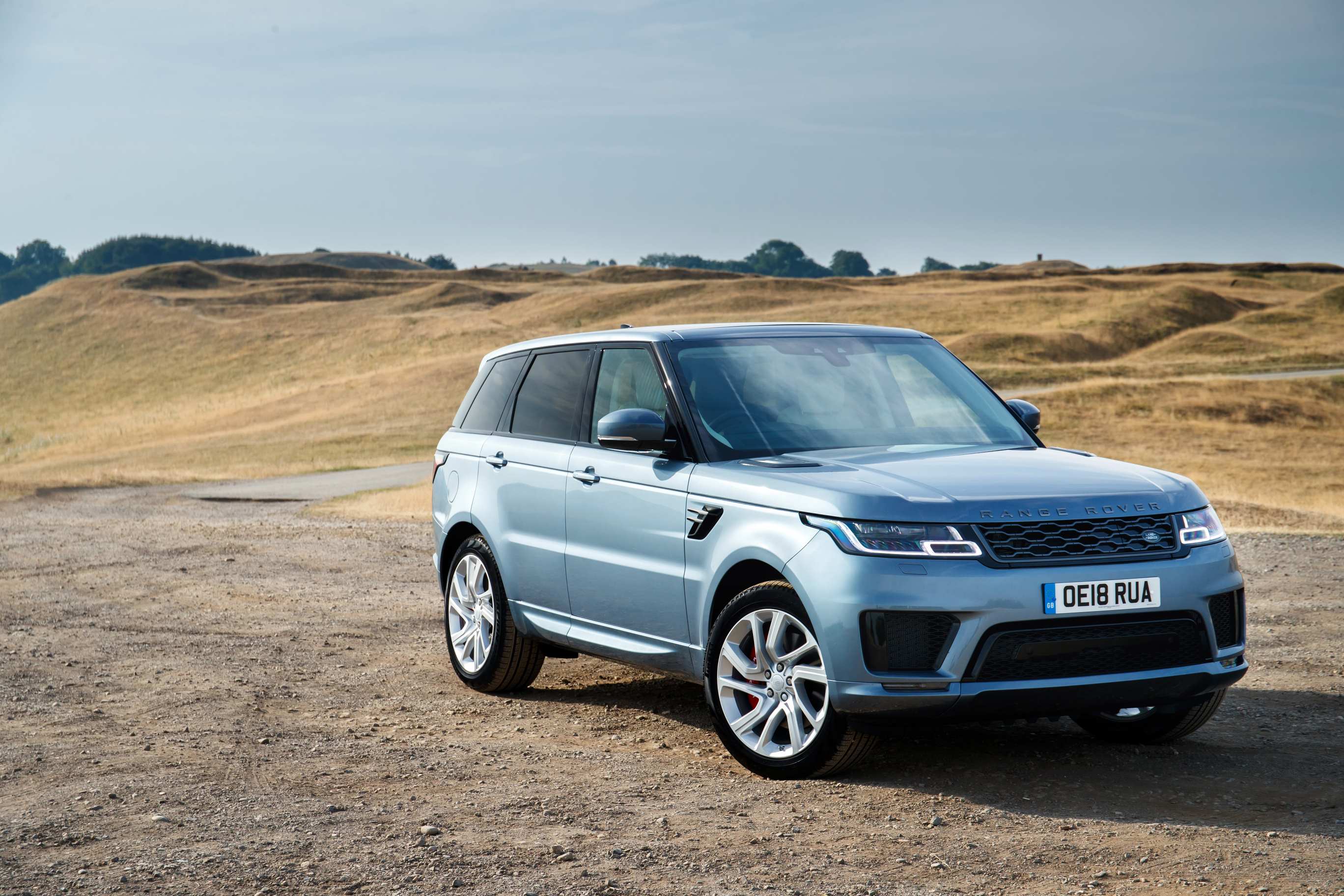 Silver Range Rover Sport p400e driving front and right side